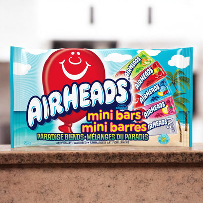 Ein Bild der Airheads Mini Bars Paradise Blends 340g Verpackung. Die Packung zeigt bunte Mini-Riegel in verschiedenen tropischen Geschmacksrichtungen.