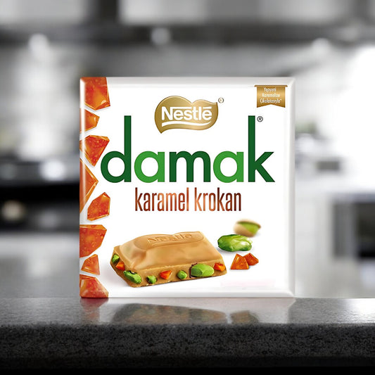 Damak Karamel Krokan 60g  Milchschokolade vereint mit knusprigen Karamellstückchen und knackigen Nüssen